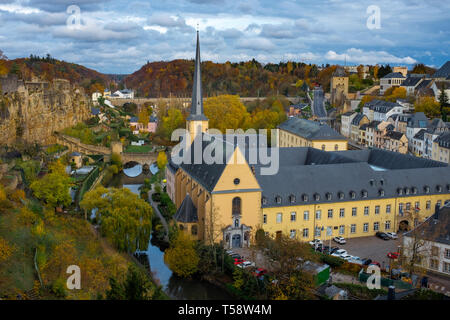 Vista dalla città alta al St Jean de Grund chiesa e monastero accanto al fiume Alzette e con il treno Adolphe ponte in background Foto Stock