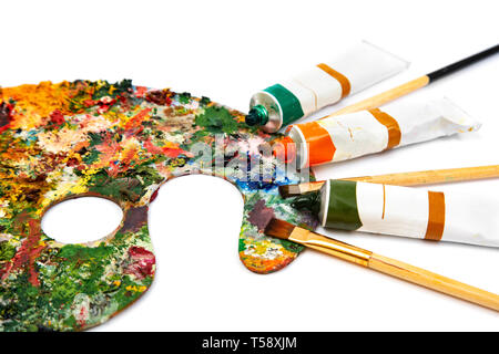 Tubi di olio multicolore di vernice e artista pennelli sulla tela closeup. Tavolozza con vernici colorate Foto Stock