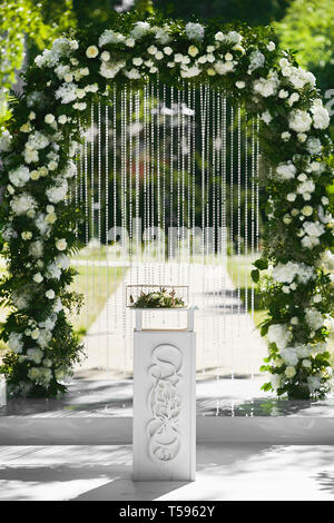 Nozze arrotondati arco floreale di fiori freschi all'aperto prima della  cerimonia di matrimonio - decorazioni per matrimoni Foto stock - Alamy