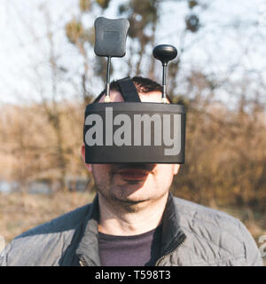 Un uomo gestisce FPV drone in occhiali VR Foto Stock