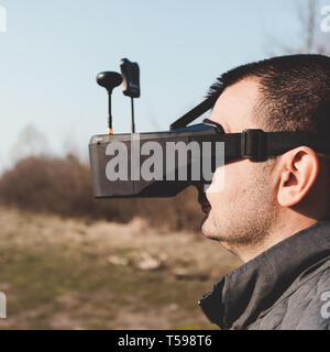 Un uomo gestisce FPV drone in occhiali VR Foto Stock