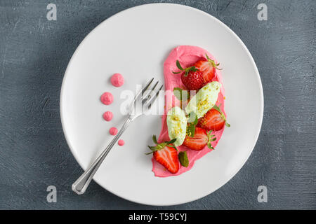 Frersh fragole con panna montata, di gelati e di zucchero in polvere . Foto Stock