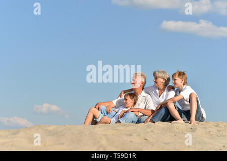 Ritratto di nonni con i loro nipoti sulla sabbia Foto Stock