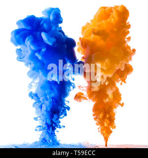 Arancione e blu schizzi di inchiostro nell'acqua, isolato su sfondo bianco Foto Stock