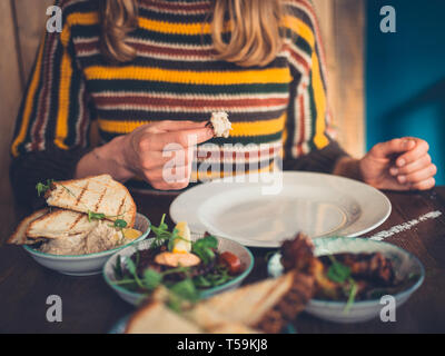 Una giovane donna è mangiare tapas in un ristorante Foto Stock