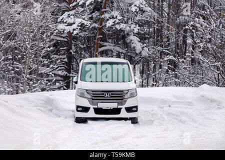 La Russia Kemerovo 2019-01-07 bianca pulita giappone minibus auto Honda Stepwgn spada ricoperta di neve. Vista frontale nella foresta d'inverno. Concetto nevicata, cattivo né Foto Stock