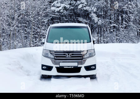 La Russia Kemerovo 2019-01-07 bianca pulita giappone minibus auto Honda Stepwgn spada ricoperta di neve. Vista frontale nella foresta d'inverno. Concetto nevicata, cattivo né Foto Stock