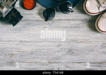 Accessori di viaggiatori su un tavolo di legno nel piatto design laici. Concetto di viaggio. Foto Stock