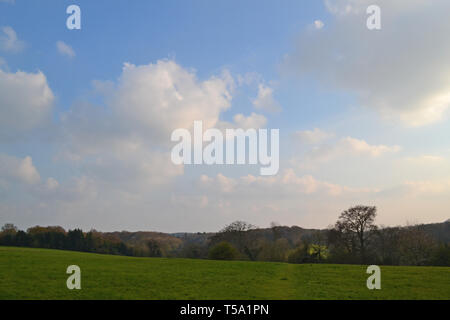 Viste della tranquilla campagna campi, boschi e cumulus nubi nei pressi di downe, Kent, Inghilterra, in primavera, guardando a sud verso Biggin Hill e Westerham. Foto Stock