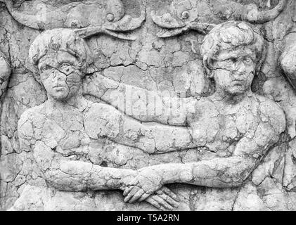 Un antico ornamenti scultorei rivela un paio di tenere su ogni altro, ancora distante, rivelando la e talvolta contrastanti la natura del matrimonio Foto Stock