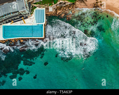 Antenna fuco colpo di onde che si infrangono sulla Bondi Iceberg Rockpool Foto Stock