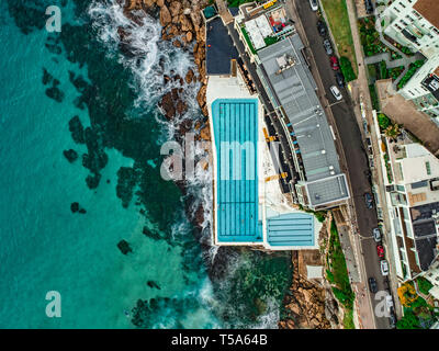 Antenna fuco colpo di onde che si infrangono sulla Bondi Iceberg Rockpool Foto Stock