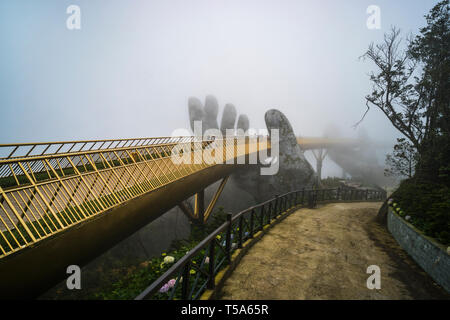 Ba Na Hill resort di montagna, Danang city, Vietnam. Il Golden Bridge è sollevata da due mani giganti nella località turistica sulla ba Na collina in un giorno di nebbia a Foto Stock