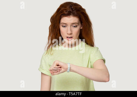 Preoccupato redhead ragazza guarda guarda il tempo di controllo Foto Stock