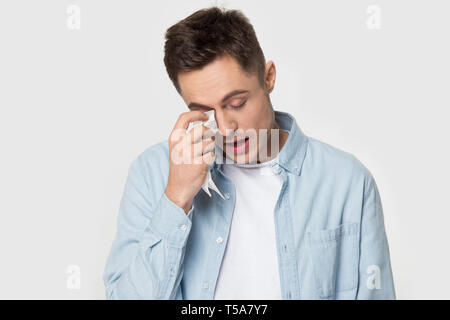 Ha sottolineato l'uomo sente verso il basso asciugare le lacrime a piangere in studio Foto Stock