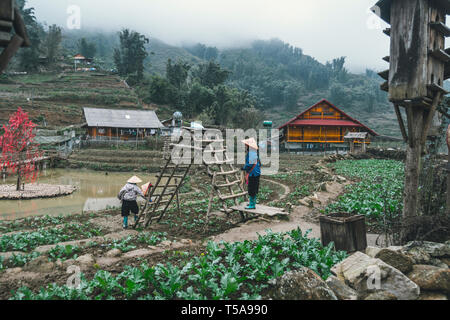 Due donne stanno lavorando in giardino nel villaggio di CatCat, Vietnam. La vita rurale dell'entroterra vietnamita. Duro lavoro agricolo. Foto Stock