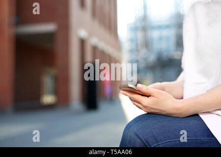 Una donna con il telefono. Scrittura dei messaggi sul communicator sullo smartphone. Foto Stock