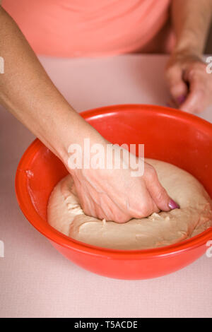 Donna giù di punzonatura una ciotola di pane naan, prima di formare nella piana di pezzi di pane per essere cotto al forno. (MR) Foto Stock