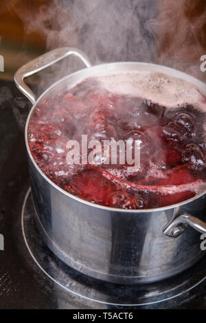 Le barbabietole a cottura in acqua bollente in preparazione per canning decapati barbabietole. Foto Stock