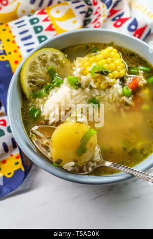Coriandolo peruviana la zuppa di pollo o Aguadito de Pollo con yukon gold patate sulla pannocchia di mais e la calce e slice Foto Stock