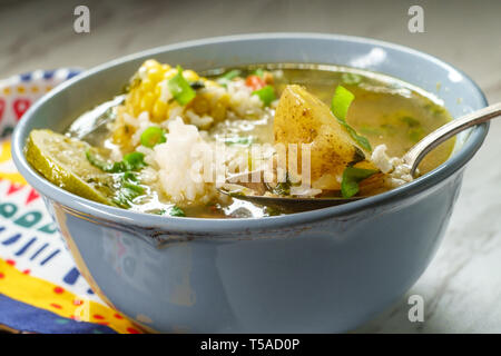 Coriandolo peruviana la zuppa di pollo o Aguadito de Pollo con yukon gold patate sulla pannocchia di mais e la calce e slice Foto Stock