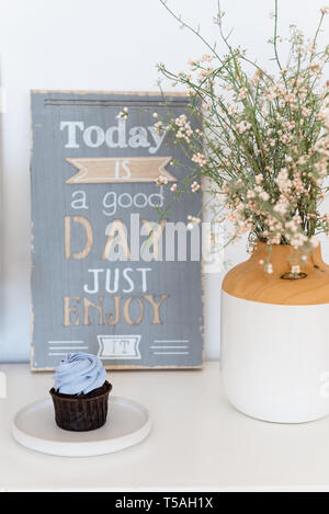 Tortina sul tavolo bianco con una frase godere di esso e Vaso con fiori. La motivazione. Dieta, mangiare sano. Foto Stock