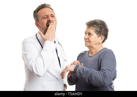 Donna anziana paziente puntando con il dito indice al polso per stanco medico a sbadigliare come tempo di ritardo concetto isolato su bianco di sfondo per studio Foto Stock