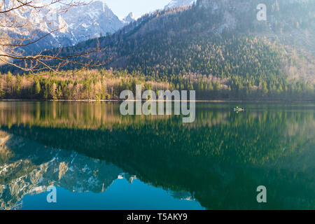 Vista panoramica di una barca da pesca barca a remi lungo con il grande paesaggio riflettendo sulle acque cristalline del Vorderer Langbathsee, OÖ, Austria Foto Stock