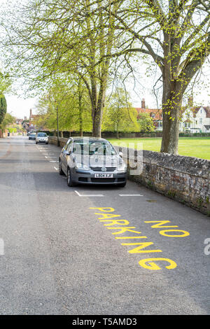 Nessun segno di parcheggio in vernice gialla sulla superficie stradale con auto parcheggiate in designato residente della baia di parcheggio Foto Stock