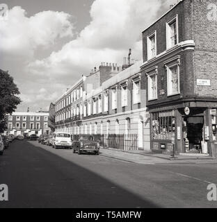 Anni sessanta, storico vista della Groenlandia Road, London, NW1, con il suo distintivo Georgiani terrazzati alloggiamento e con l'angolo shop, il negozio di generi alimentari e i giornalai, F. Un Townsend con la porta aperta, visto in corrispondenza della giunzione con Carol Street. Foto Stock