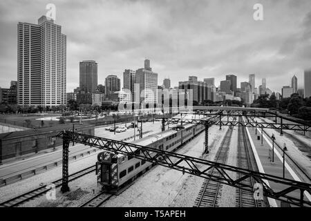 Metra treno in partenza Campus / 11th Street fermata a Chicago, Illinois, Stati Uniti d'America in bianco e nero Foto Stock