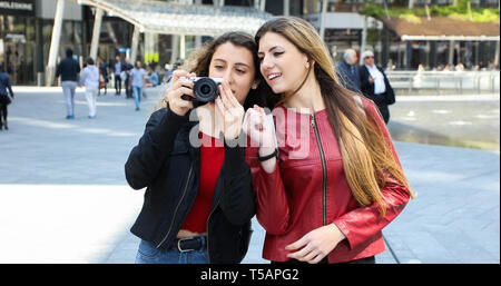 Le ragazze fare fotografie con la fotocamera al di fuori della città Foto Stock