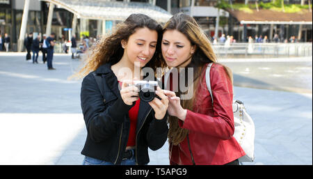 Le ragazze fare fotografie con la fotocamera al di fuori della città Foto Stock