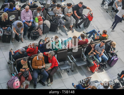 Londra, Regno Unito. 22 apr, 2019. I passeggeri in attesa nella sala partenze in una trafficata Pasqua lunedì festivo come aeroporto di Heathrow annuncia un aumento del numero di passeggeri per la ventinovesima mese in una fila come 6,5 milioni di passeggeri passati attraverso il Regno Unito aeroporto più trafficato di marzo, una media di 210.000 al giorno. L'aumento è stato 0,5 per cento rispetto allo stesso mese del 2018, che rappresenta un ulteriore 1.000 passeggeri al giorno. Credito: amer ghazzal/Alamy Live News Foto Stock