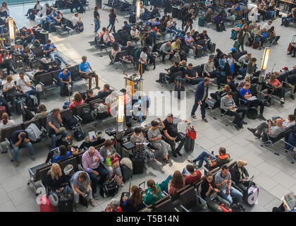 Londra, Regno Unito. 22 apr, 2019. I passeggeri in attesa nella sala partenze in una trafficata Pasqua lunedì festivo come aeroporto di Heathrow annuncia un aumento del numero di passeggeri per la ventinovesima mese in una fila come 6,5 milioni di passeggeri passati attraverso il Regno Unito aeroporto più trafficato di marzo, una media di 210.000 al giorno. L'aumento è stato 0,5 per cento rispetto allo stesso mese del 2018, che rappresenta un ulteriore 1.000 passeggeri al giorno. Credito: amer ghazzal/Alamy Live News Foto Stock