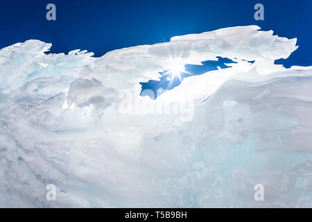 Congelati rime di ghiaccio in una formazione di arco vicino al picco del Monte Shasta, California. Il sole splende attraverso l'arco con un lens flare di seguito. Foto Stock