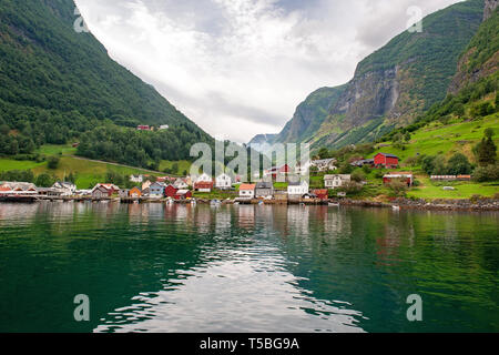 Le piccole case del comune sul fiordo, fotografata da una crociera turistica traghetto in partenza in estate da Flam, Norvegia vista di un villaggio sul bordo Foto Stock