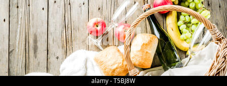 Cesto per pic-nic con cibi e bevande (frutta fresca, pane e bottiglia di vino, bicchieri), copia spazio banner Foto Stock