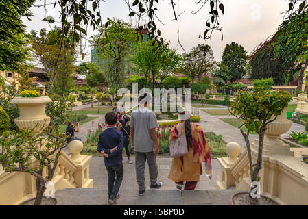 KATHMANDU, NEPAL - MARZO 30, 2019: indiana i visitatori a piedi verso il basso passi al tramonto nel recentemente rinnovato splendidamente, lussureggianti ancora curato giardino Foto Stock