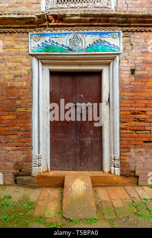 Vecchio decorato stile Newari porta prese durante un parzialmente soleggiato mattina nel centro storico di Bhaktapur, Nepal Foto Stock