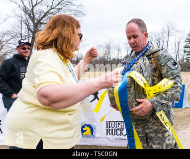 Soldato che partecipano nella dura Ruck, che ha attraversato la maratona finale linea portante non solo la sua ruck sack ma anche di quello appartenente ad un altro. Foto Stock