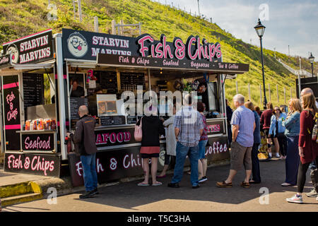 Persone formando una coda ordinata a Starvin Marvin's pesce mobili e chip van su Cromer fronte mare. Con il chip negozi nel centro città essendo excepti Foto Stock