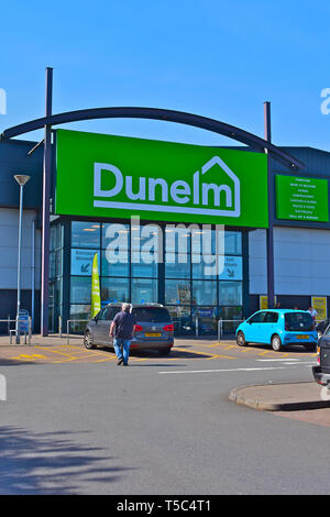 L'ingresso anteriore del negozio Dunelm trova il Parc Plaza, Waterton Croce, Bridgend. Uomo che cammina attraverso il parco auto verso il magazzino. Foto Stock