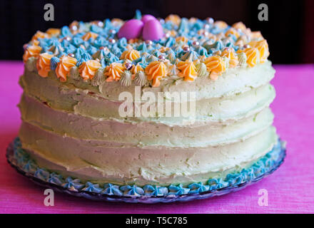 Torta di Pasqua in diversi colori con caramelle sulla parte superiore Foto Stock