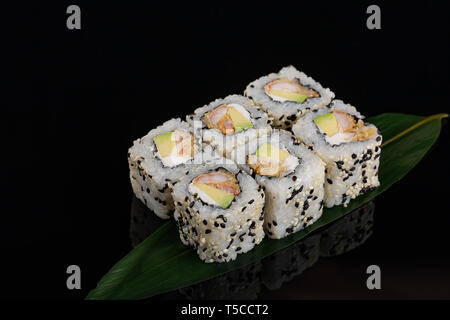Vista ingrandita di Filadelfia giapponese sushi tempura di gamberetti rotolo su sfondo nero. Foto Stock