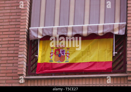 Spanish flag pendente da un balcone in un stato membro spagnolo città per indicare la nazionale spagnola di fervore patriottico Foto Stock