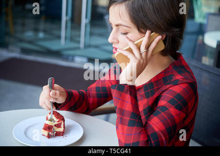 Bella donna di mangiare la torta Foto Stock