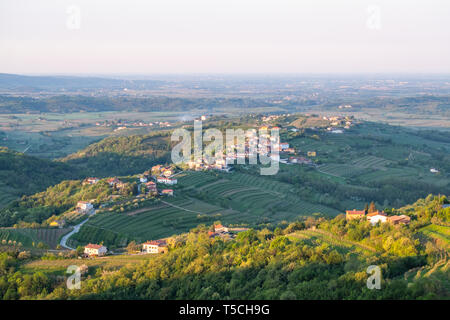 Piccolo villaggio Kozana su sunrise tra i vigneti in produzione vinicola della regione Brda in Slovenia vicino alla frontiera con l'Italia in Europa Foto Stock