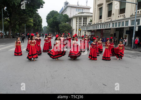 Bambine e bambini vestiti in abito tradizionale danza sulla strada sorridente in Hanoi. Il Vietnam. 13 Gennaio 2019 Foto Stock