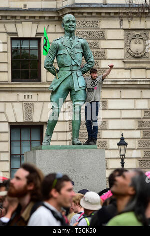 Londra, Regno Unito. 22 apr, 2019. Un attivista si arrampica la statua di Jan granello di fuliggine a Piazza del Parlamento durante il 'London: International Rebellion', il giorno nove di una protesta organizzata dalla ribellione di estinzione. I dimostranti chiedono che i governi stanno prendendo provvedimenti contro il cambiamento climatico. La polizia ha rilasciato una sezione 14 ordine per la piazza del Parlamento e si aspettano che l occupazione della piazza avrà concluso entro la fine della giornata. Credito: Stephen Chung/Alamy Live News Foto Stock